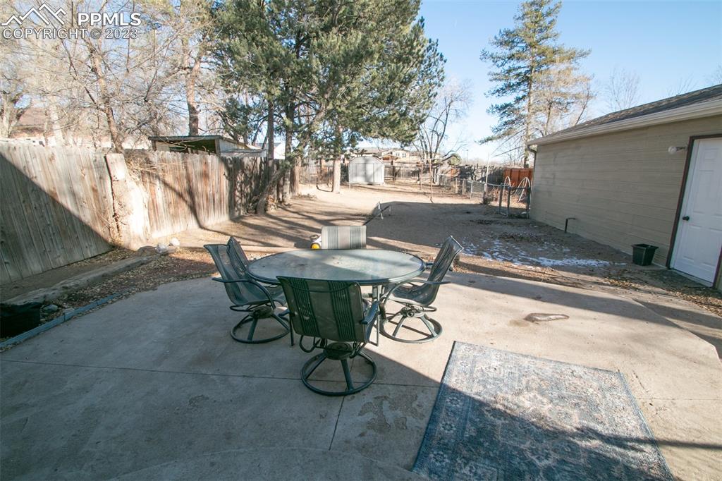 915 Alexander Road Colorado Springs, CO 80909 - Photo 21 of 24 a view of backyard with table and chairs with wooden fence