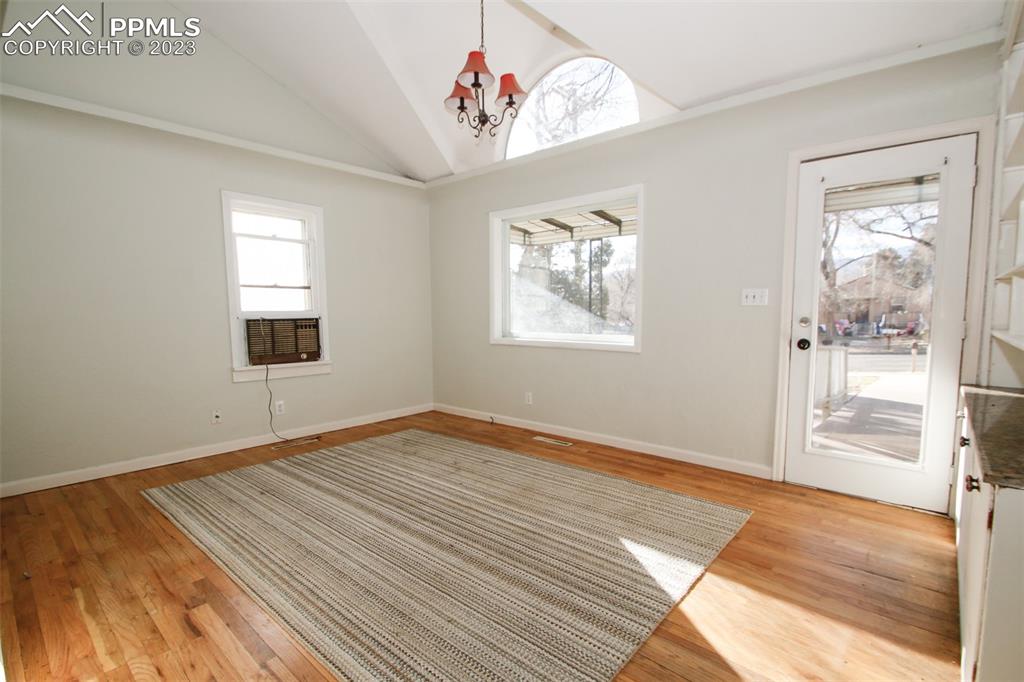 915 Alexander Road Colorado Springs, CO 80909 - Photo 9 of 24 a view of an empty room with wooden floor and a window