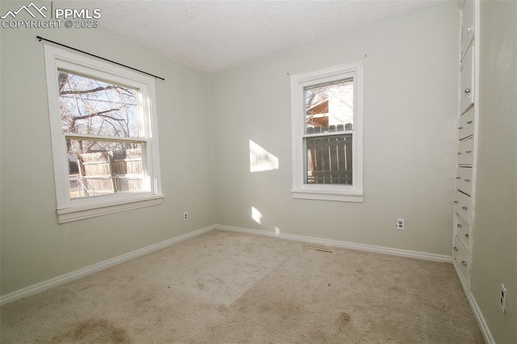 915 Alexander Road Colorado Springs, CO 80909 - Photo 10 of 24 a view of empty room with windows