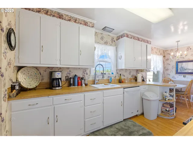 a utility room with stainless steel appliances kitchen island a stove a refrigerator and cabinets