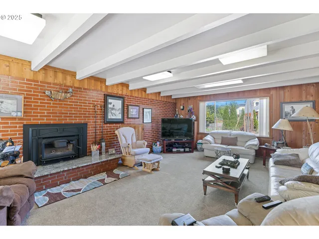 a living room with furniture a large window and a chandelier