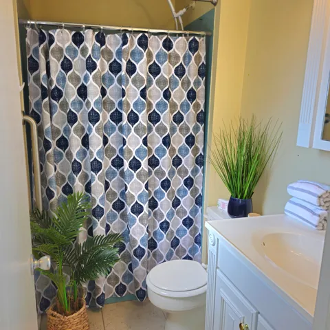 a bathroom with a granite countertop toilet and a sink