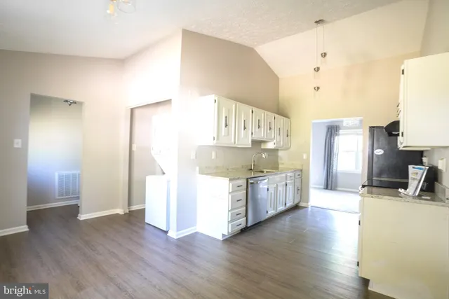 a view of a hallway with wooden floor and a living room
