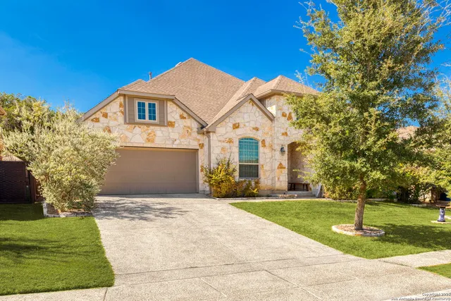 a front view of a house with a yard and trees