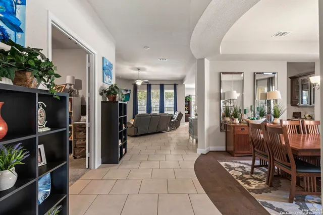 a living room with furniture a dining table and a potted plant