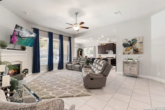 a living room with furniture a fireplace and a flat screen tv