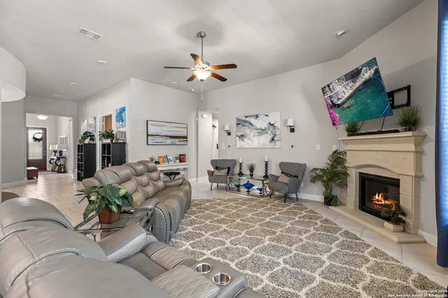 a living room with furniture a flat screen tv and a fireplace