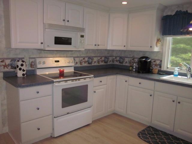 110 Guildford Road Centerville, MA 02632 - Photo 2 of 25 a kitchen with white cabinets and white appliances