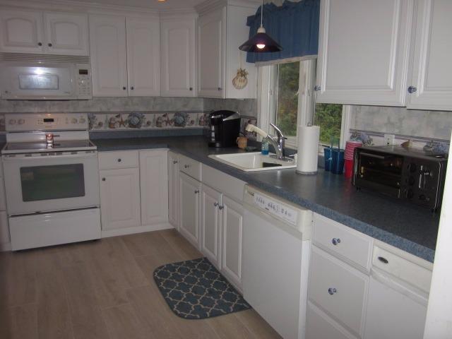 110 Guildford Road Centerville, MA 02632 - Photo 4 of 25 a kitchen with white cabinets and appliances