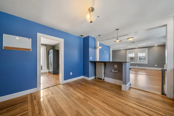 a kitchen with granite countertop wooden floors stainless steel appliances a sink and a window