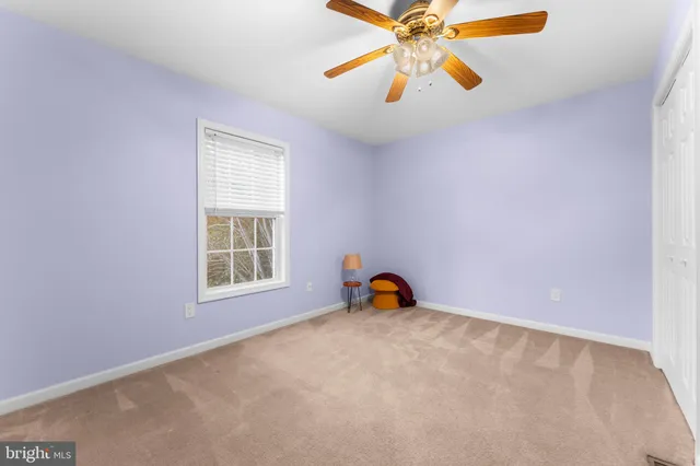 an empty room with closet and a chandelier fan