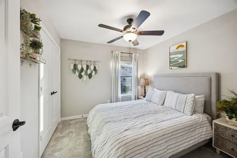 a bedroom with a large bed and a chandelier