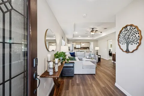 a living room with furniture a mirror and a chandelier