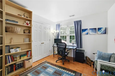 a view of a workspace with furniture and a book shelf