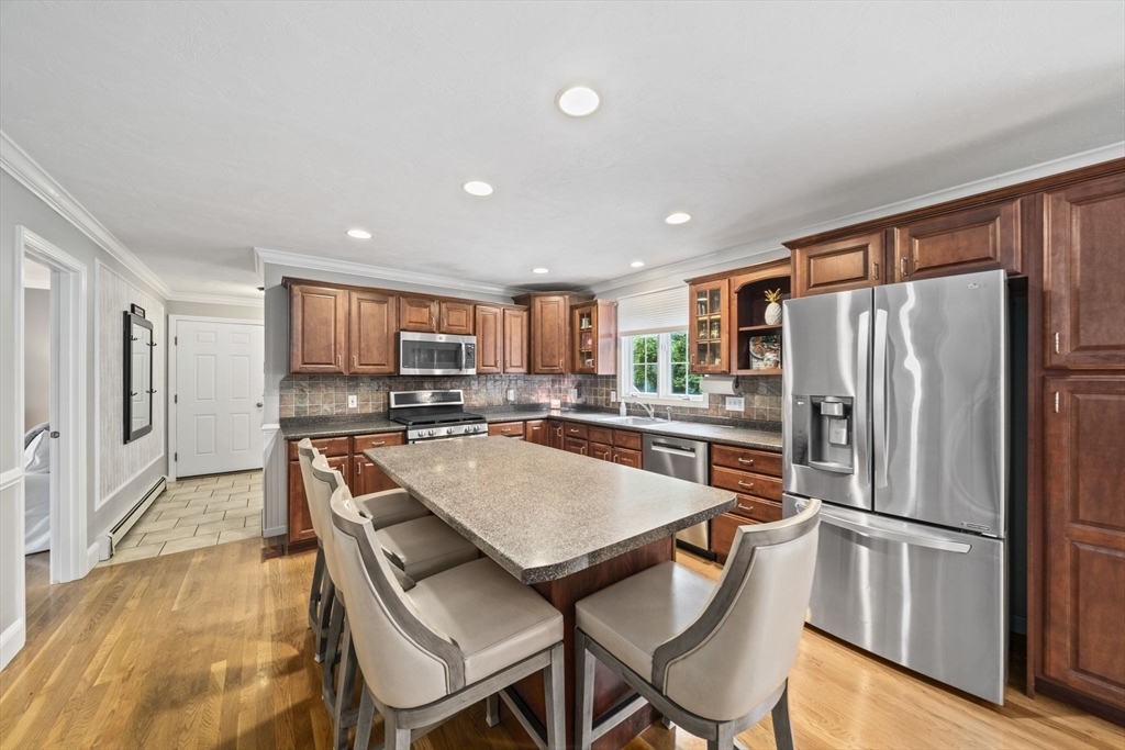 36 Meadow Lane Hanson, MA 02341 - Photo 3 of 36 a kitchen with stainless steel appliances granite countertop a refrigerator a stove a sink a dining table and chairs with wooden floor