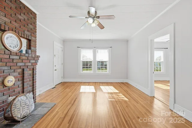 a view of empty room with a window and wooden floor