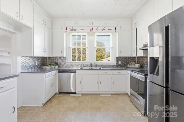a kitchen with stainless steel appliances granite countertop a refrigerator sink and stove