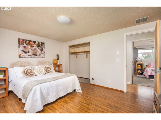 a bedroom with a bed and painting on the wall