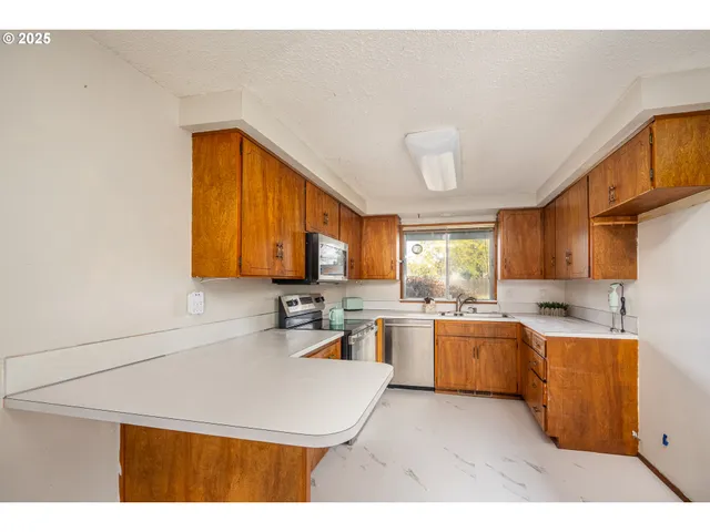 a kitchen with a sink a stove and cabinets