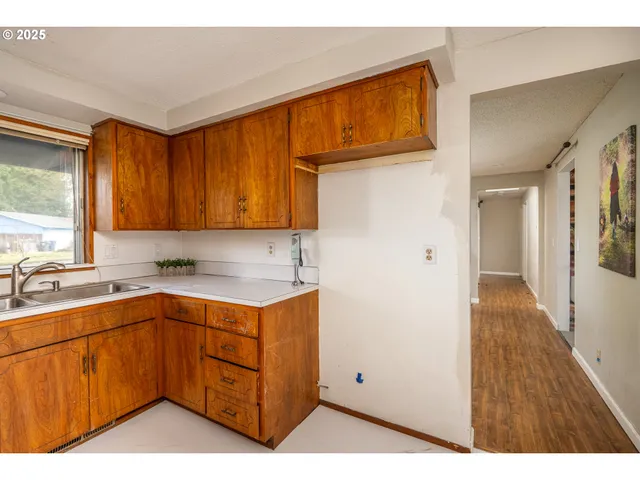 a kitchen with a sink cabinets appliances and a window
