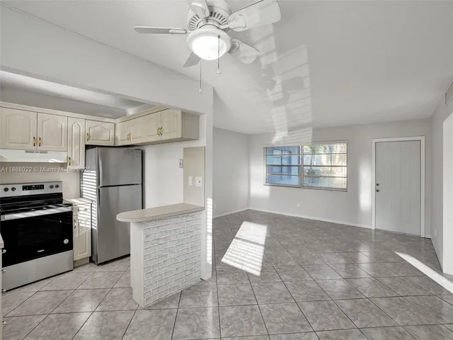 a large kitchen with cabinets a sink and stainless steel appliances