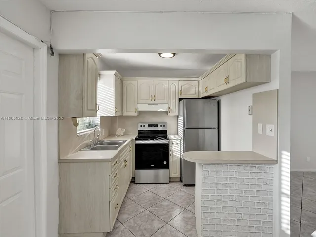 a kitchen with stainless steel appliances granite countertop a refrigerator and a stove top oven