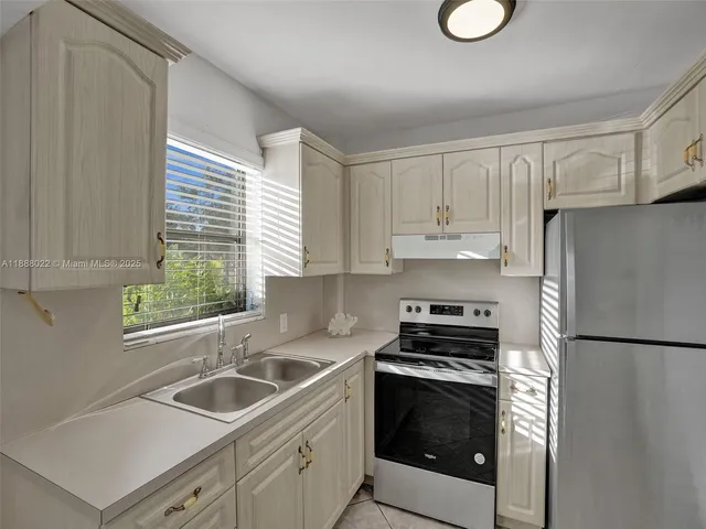 a kitchen with stainless steel appliances granite countertop a refrigerator sink and stove