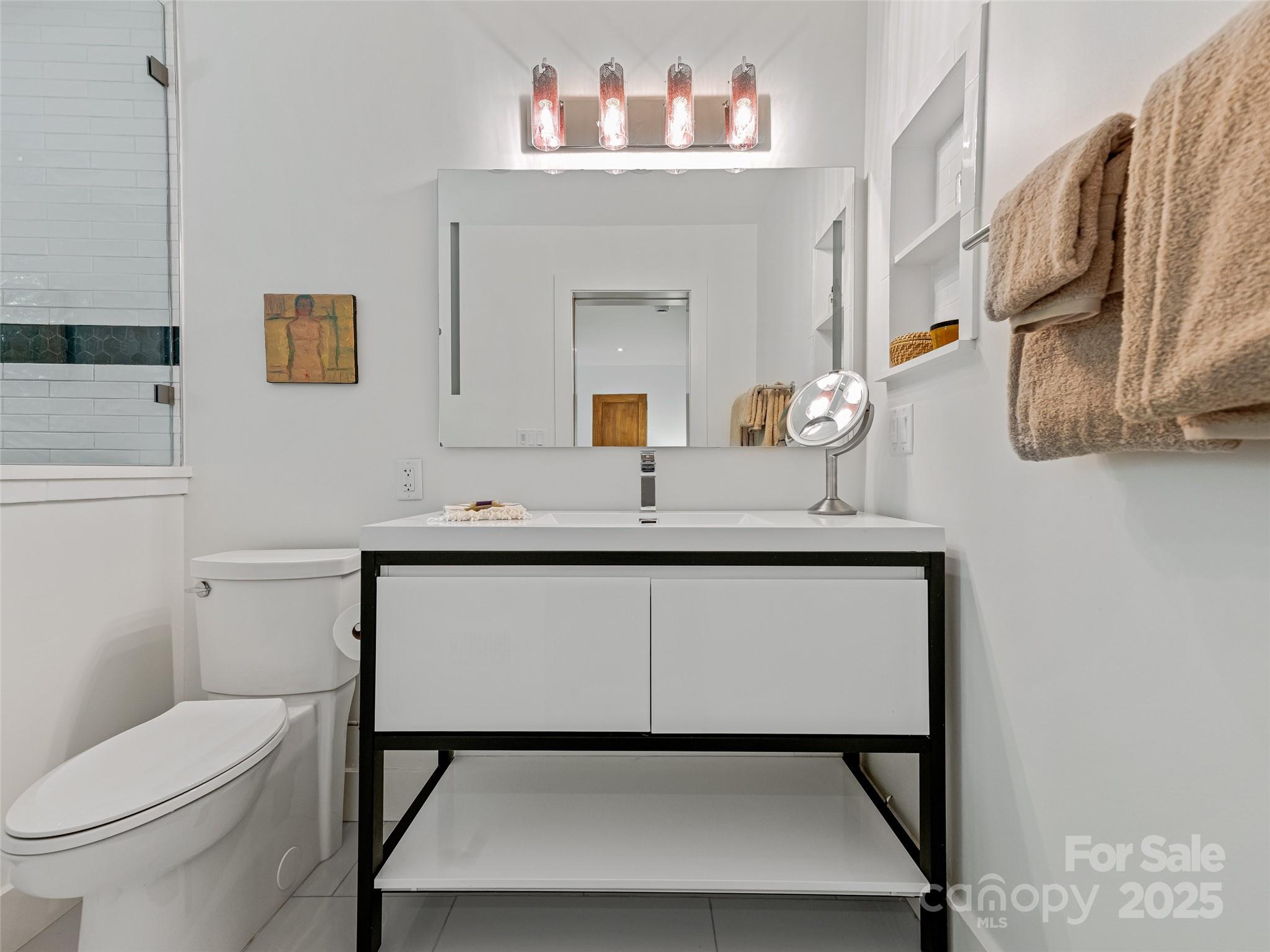 5 Brookside Road Asheville, NC 28803 - Photo 37 of 45 a bathroom with a toilet a sink and mirror