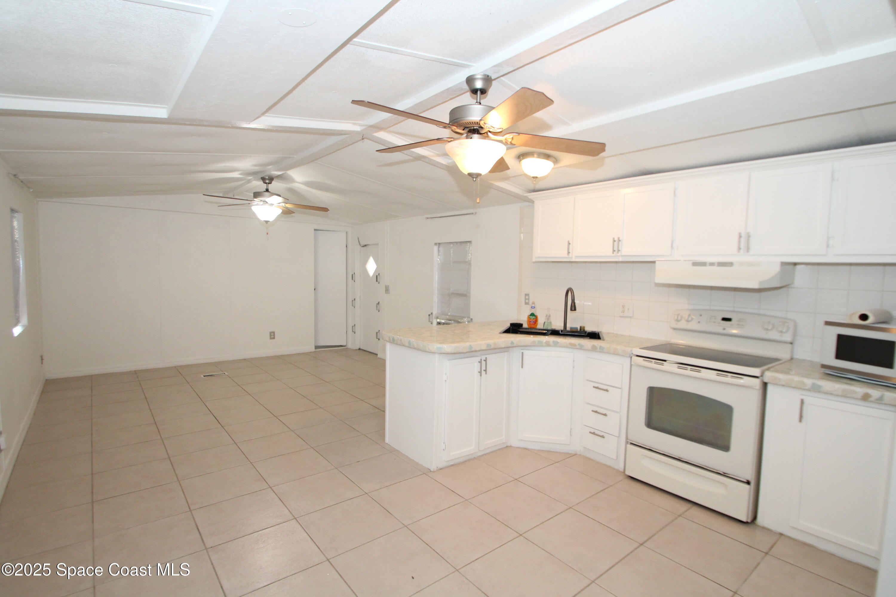 2132 Rocway Drive Melbourne, FL 32935 - Photo 5 of 8 a kitchen with cabinets and white appliances