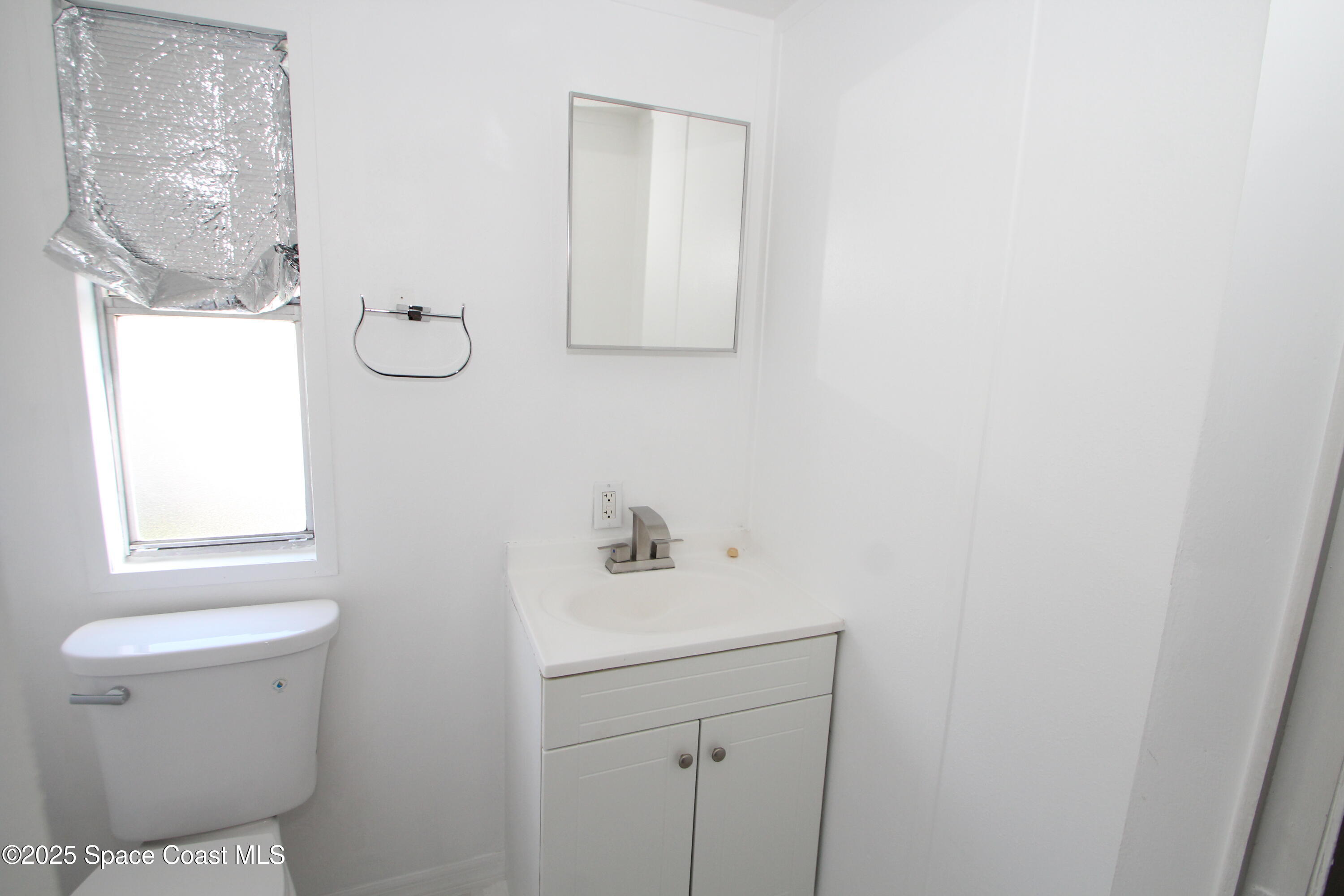 2132 Rocway Drive Melbourne, FL 32935 - Photo 8 of 8 a bathroom with a sink a toilet and a mirror