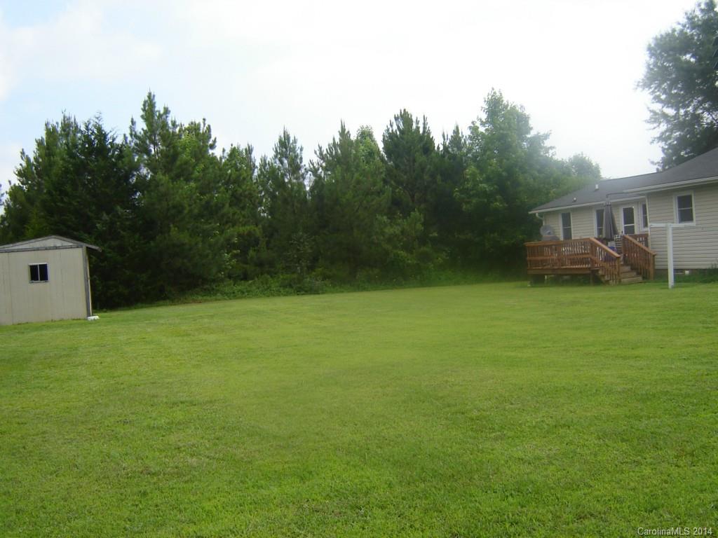 1007 Mills Harris Road Wingate, NC 28174 - Photo 22 of 24 a backyard of a house with plants and large tree