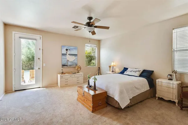 a spacious bedroom with a bed couch and windows