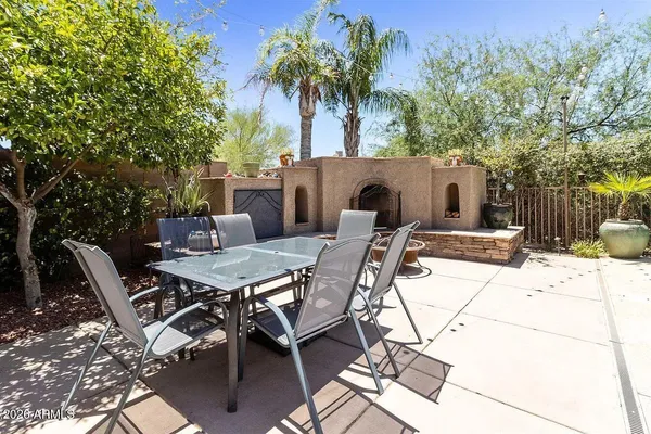 a view of a patio with a table and chairs under an umbrella