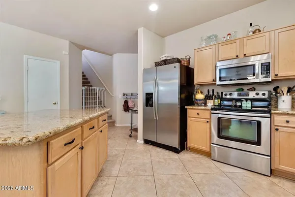a kitchen with stainless steel appliances granite countertop a refrigerator and a stove top oven