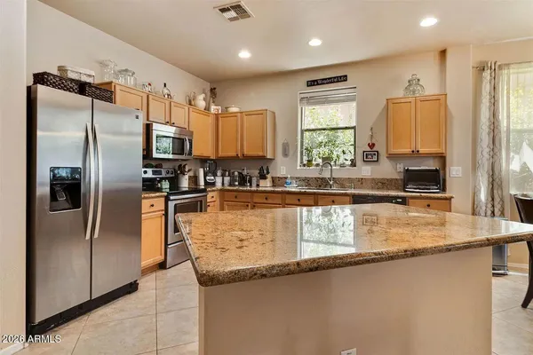 a kitchen with stainless steel appliances granite countertop a refrigerator a sink and a stove