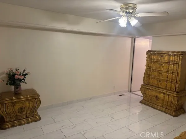 a view of a livingroom with a chandelier fan and a potted plant