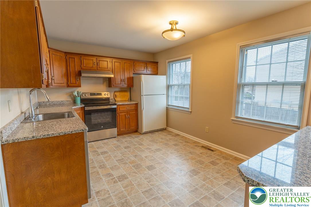1049 Barnside Road Allentown, PA 18103 - Photo 6 of 19 a kitchen with granite countertop a stove a sink and a refrigerator