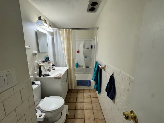 a bathroom with a sink a toilet a mirror and shower