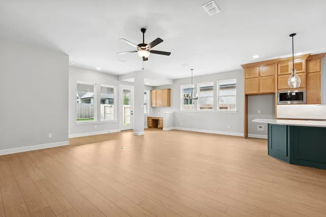 an empty room with windows and fan