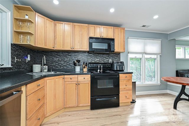 a kitchen with stainless steel appliances granite countertop a stove sink and cabinets