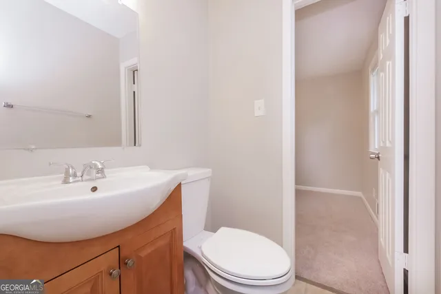 a bathroom with a sink a toilet and mirror