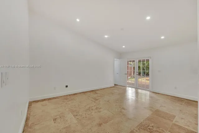 a kitchen with granite countertop a sink and white cabinets