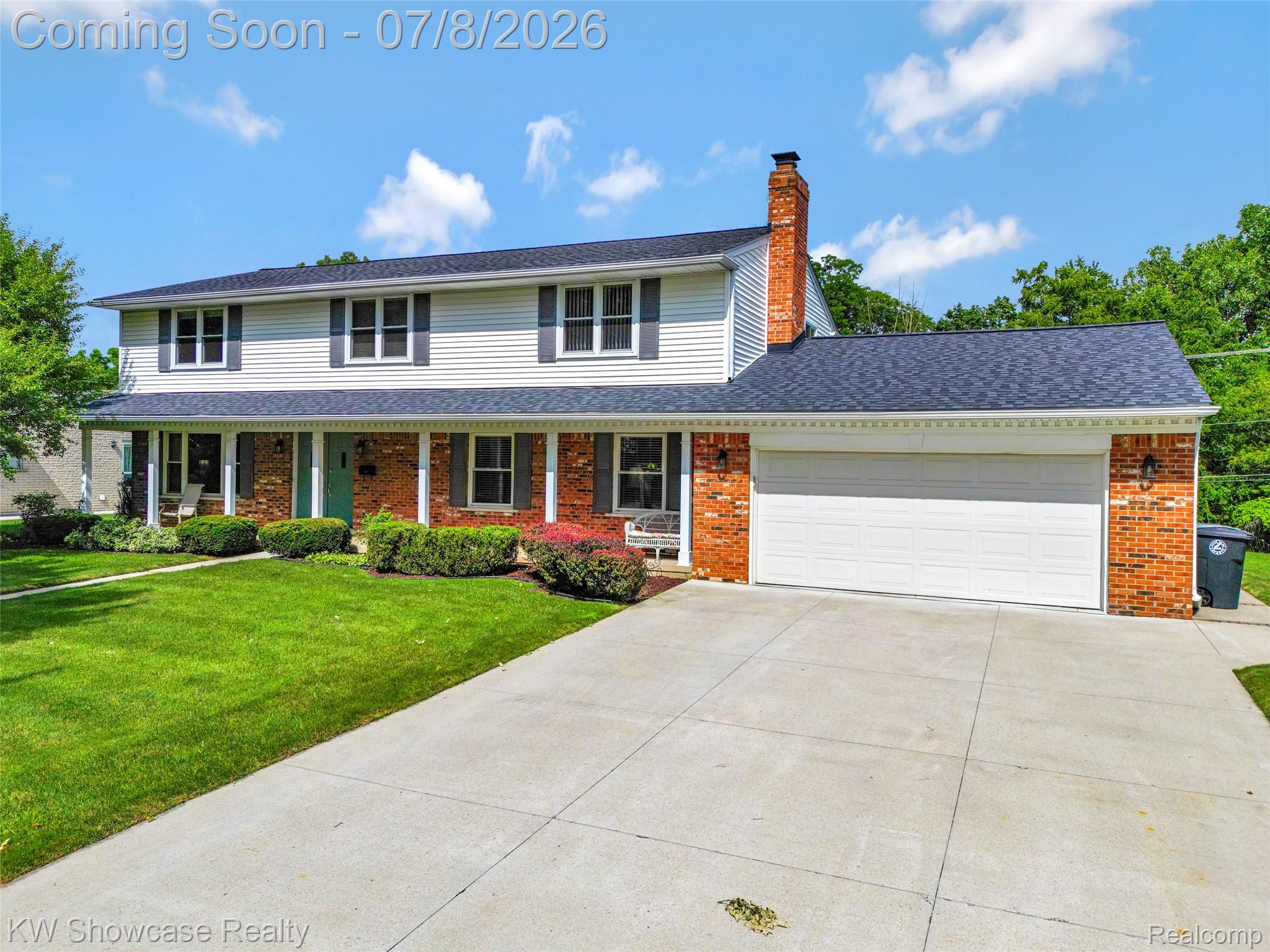 16720 Wayne Road Livonia, MI 48154 - Photo 2 of 29 Traditional two-story residence featuring a brick and siding facade, a covered front porch, and a two-car garage