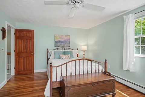 a view of a bedroom with furniture window and wooden floor