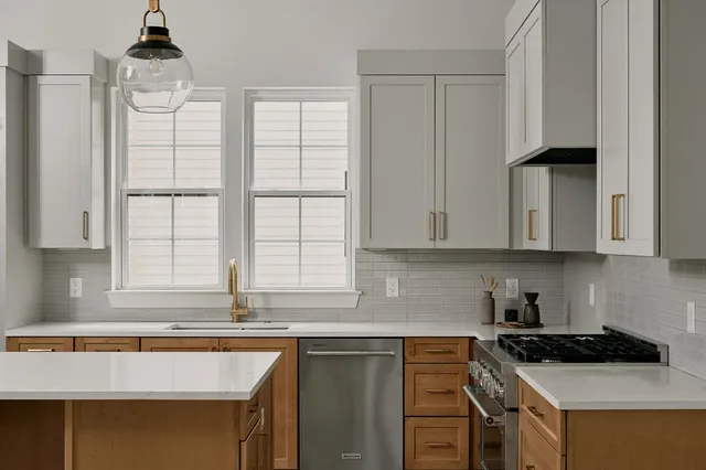a kitchen with stainless steel appliances granite countertop a sink stove and cabinets