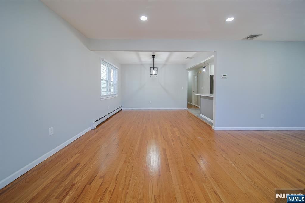 314 Garibaldi Avenue, Unit 1 Lodi, NJ 07644 - Photo 11 of 35 an empty room with wooden floor and windows