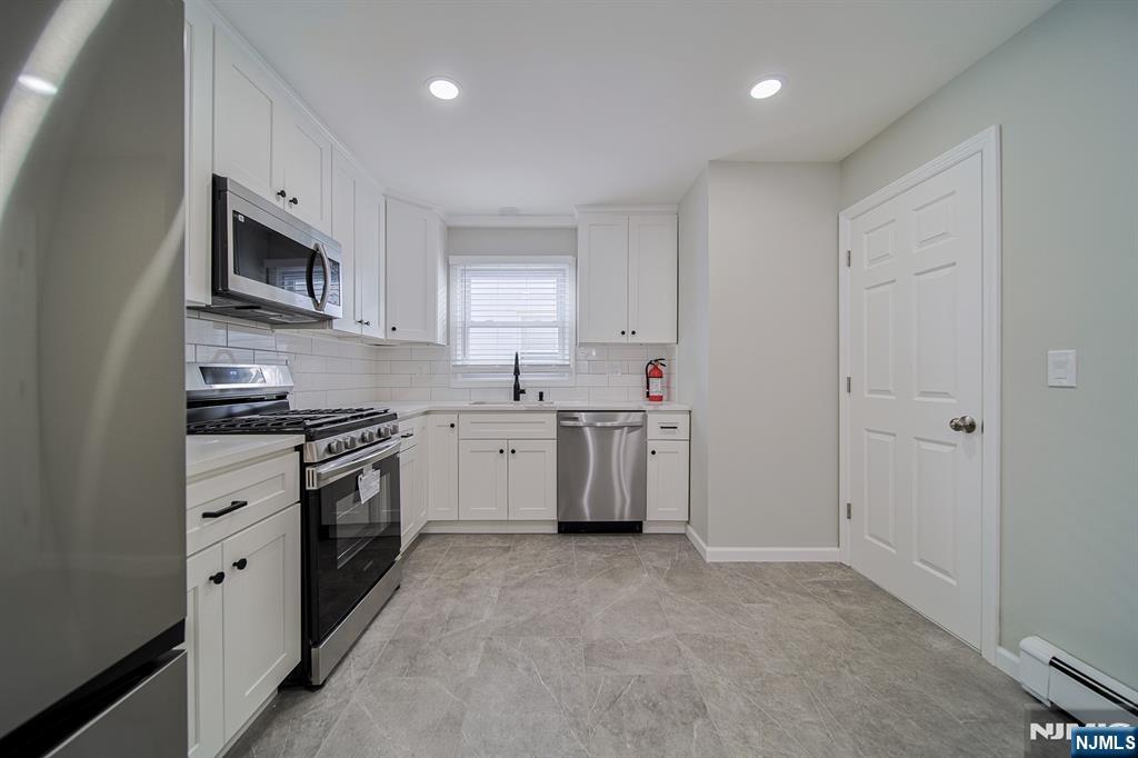 314 Garibaldi Avenue, Unit 1 Lodi, NJ 07644 - Photo 16 of 35 a kitchen with stainless steel appliances granite countertop a sink a stove a refrigerator and a microwave