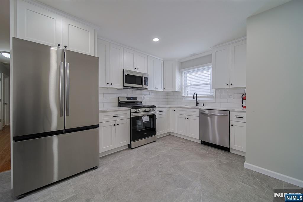 314 Garibaldi Avenue, Unit 1 Lodi, NJ 07644 - Photo 17 of 35 a kitchen with stainless steel appliances a refrigerator sink and white cabinets