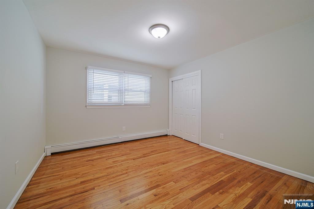 314 Garibaldi Avenue, Unit 1 Lodi, NJ 07644 - Photo 19 of 35 an empty room with wooden floor and windows