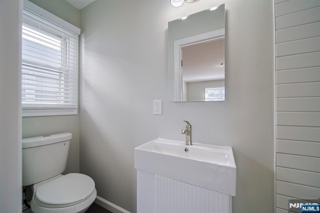 314 Garibaldi Avenue, Unit 1 Lodi, NJ 07644 - Photo 25 of 35 a bathroom with a toilet a sink a mirror and a window